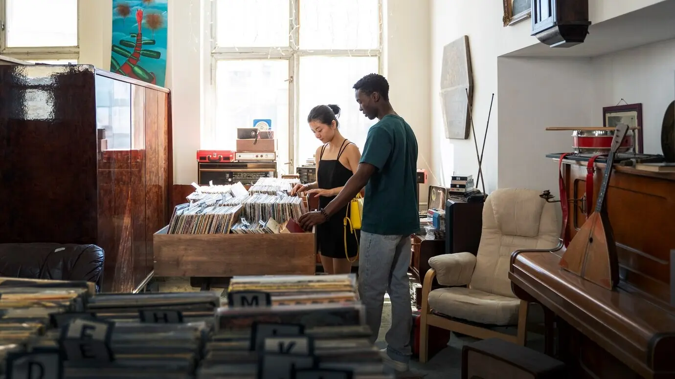 Ganzkörperaufnahme von Menschen mit Schallplatten.