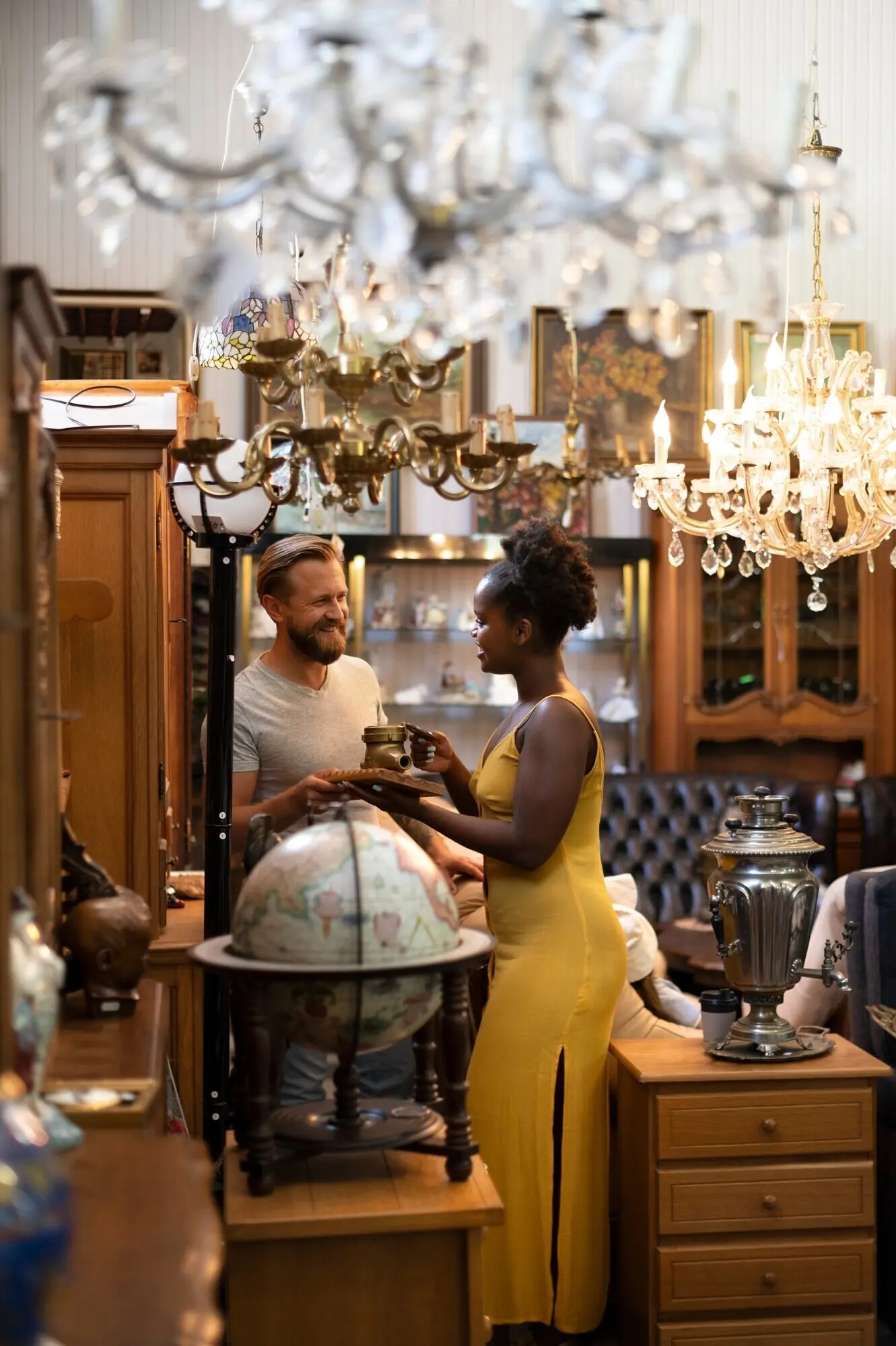 Ganzkörperaufnahme lächelnder Menschen im Antiquitätengeschäft.